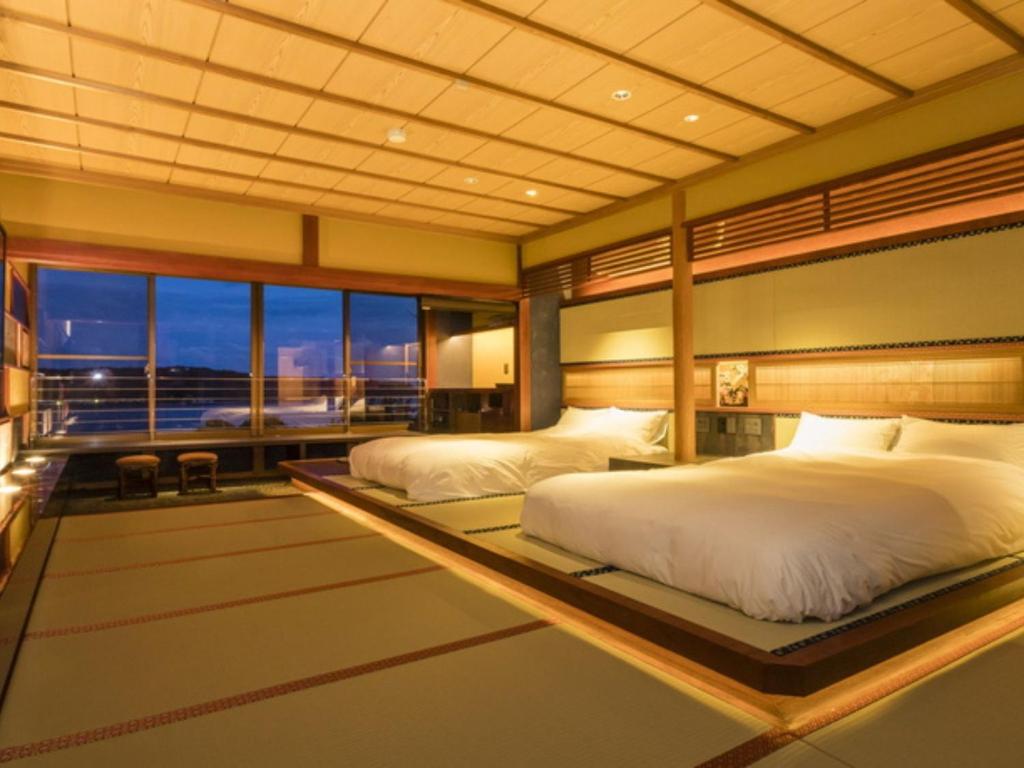 Postel nebo postele na pokoji v ubytování Kurofune Hotel