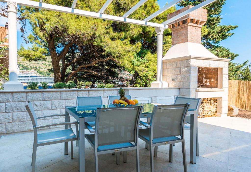 una mesa y sillas en un patio con chimenea en Apartment Luxe, en Dubrovnik