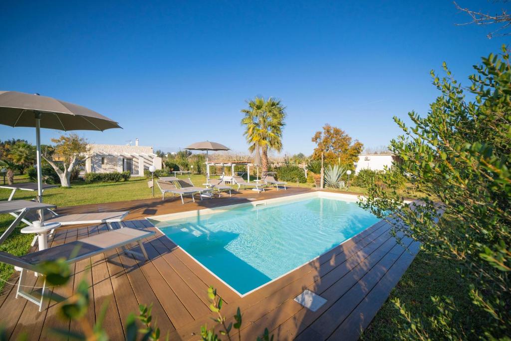 a swimming pool with chairs and an umbrella at Villa Assunta With Pool Near The Sea - Happy Rentals in Melendugno