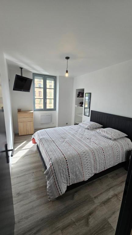 une chambre avec un grand lit dans une pièce blanche dans l'établissement Le Charme et Confort Saint -Sévère T3 Vienne, à Vienne