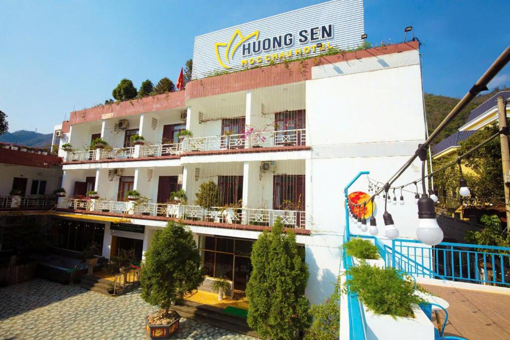 Un gran edificio blanco con un cartel en él. en Hương Sen Hotel MC - by BAY LUXURY, en Mộc Châu