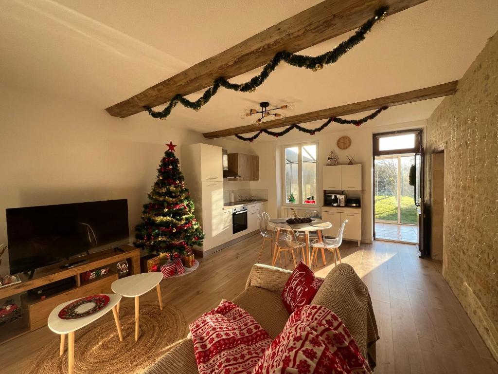 - un salon avec un arbre de Noël et un canapé dans l'établissement Le Petit Portais, à Port-en-Bessin-Huppain