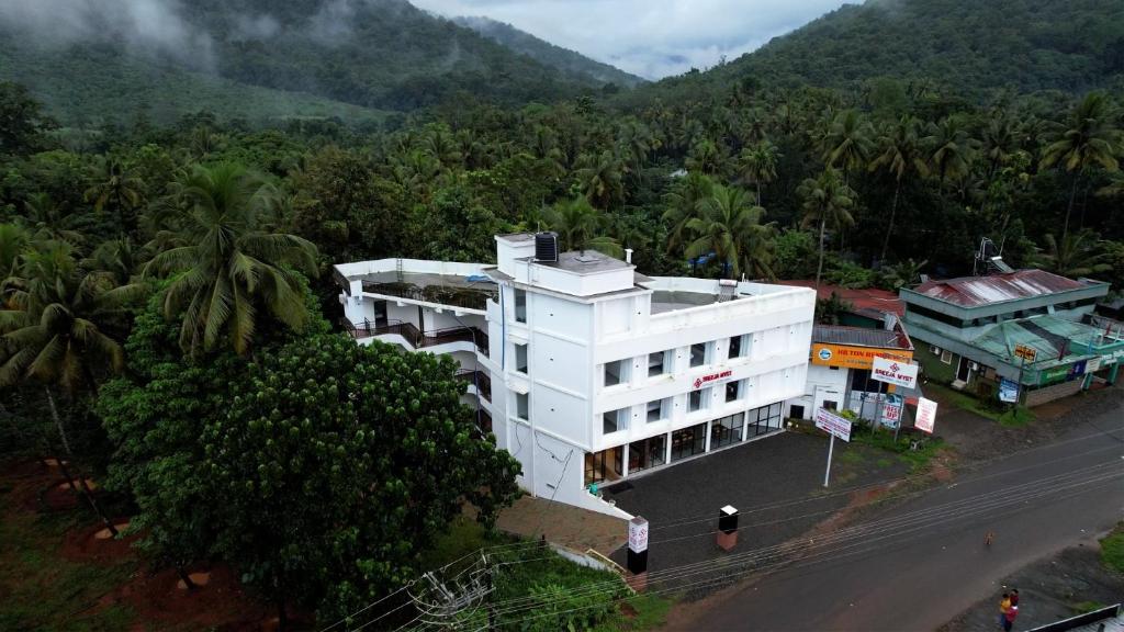 Una vista aérea de un edificio blanco en un bosque. en Sreeja Myst, en Athirappilly