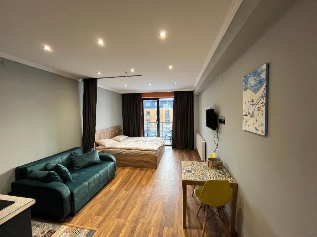 una sala de estar con un sofá y una cama en Cozy apartment in NEW GUDAURI Block F2, en Gudauri