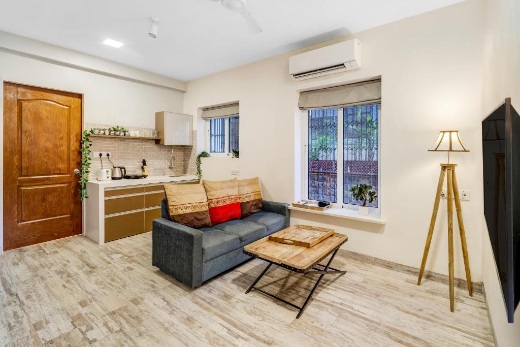 Una sala de estar con un sofá y una cocina. en Cleo 1BHK Khar W by The Bombay Home Company, en Bombay