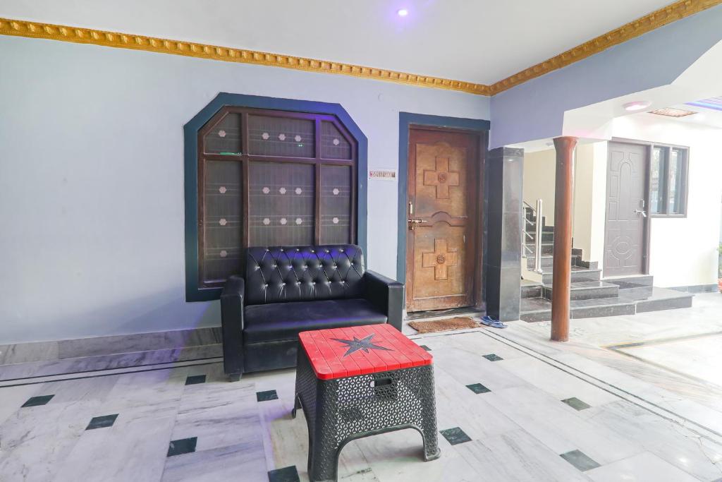 una stanza con una sedia e uno sgabello rosso di FabExpress Awadh Inn - 400m from Shri Ram Janam Bhumi a Ayodhya