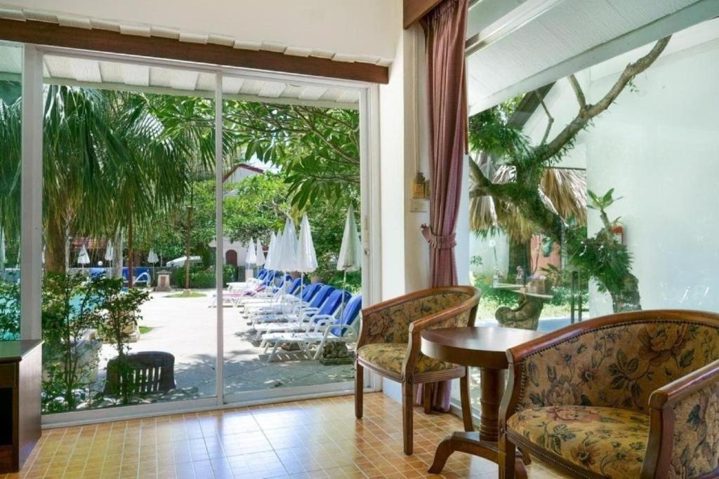 a room with a table and chairs and a sliding glass door at Garden Home Kata in Kata Beach
