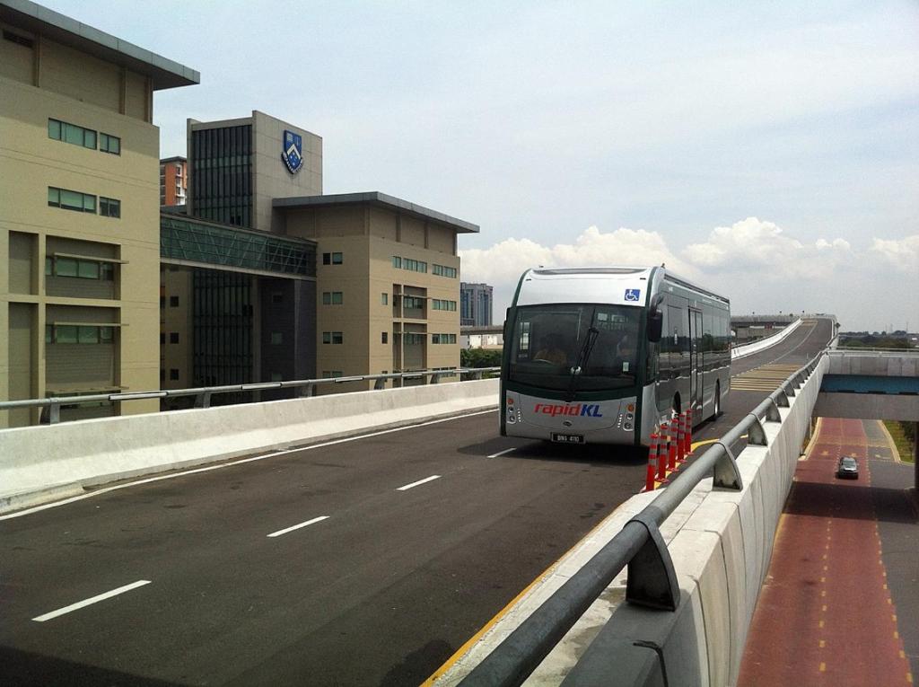 a bus driving on a highway near a building at X - The Papermill - Sunway Subang Jaya USJ1 SEGi Monash INTI Taylor Sunway Lagoon in Subang Jaya