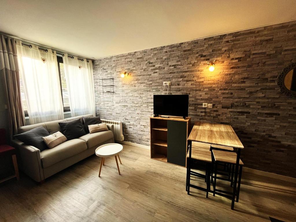 un salon avec un canapé et une table dans l'établissement l'Armazan - studio pieds de piste Plat d'Adet, à Saint-Lary-Soulan