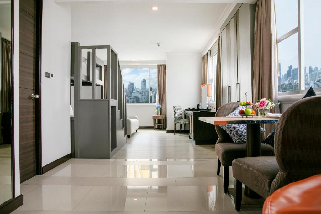 a living room with a table and chairs in a room at The Berkeley Hotel Pratunam in Bangkok