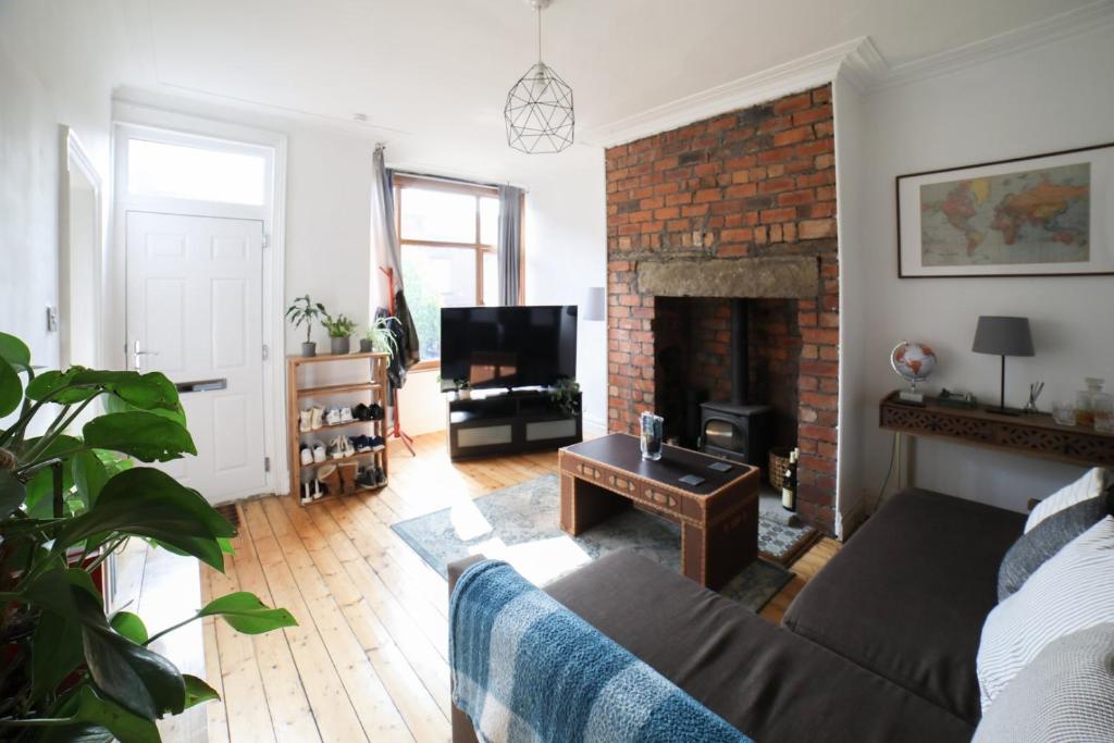 a living room with a couch and a fireplace at Dweller Holiday Homes in Headingley