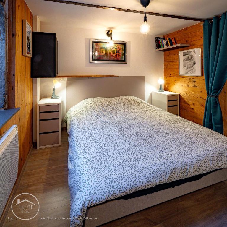 une chambre avec un lit et une télévision à écran plat dans l'établissement Le refuge du bout du monde, à Leysse