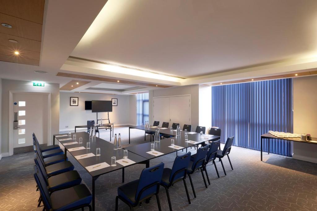 a conference room with a long table and chairs at Stamford Bridge Hotel London in London