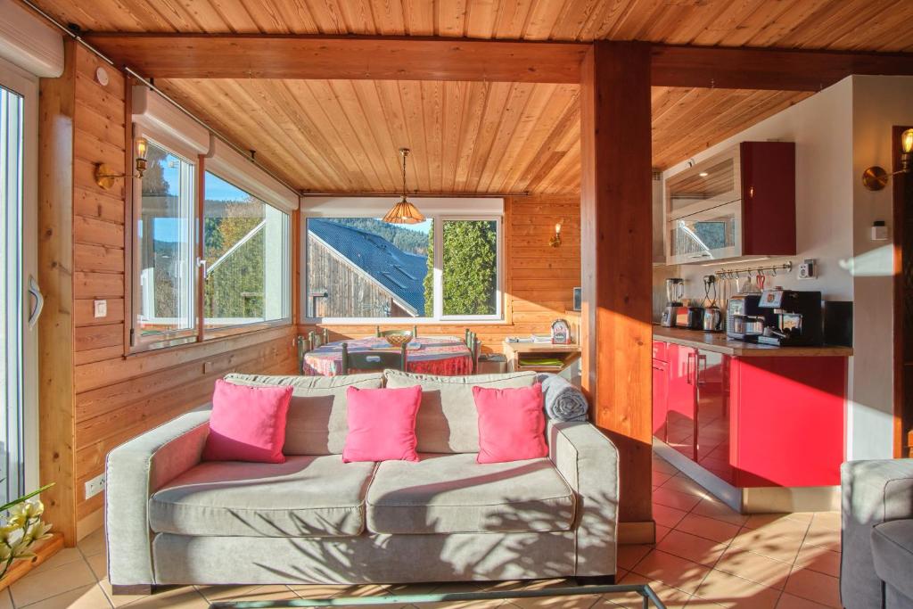 a living room with a couch with pink pillows at La Croix Du Sud in Villard-de-Lans