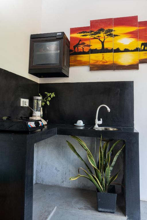 a kitchen with a sink and a microwave at DKC Apartment in Ahangama