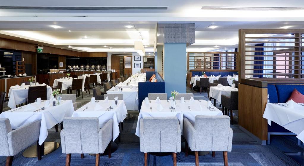 a dining room with white tables and chairs at Stamford Bridge Hotel London in London