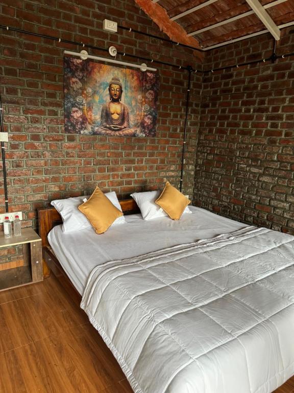 a large bed in a room with a brick wall at Amorah in Kanakapura