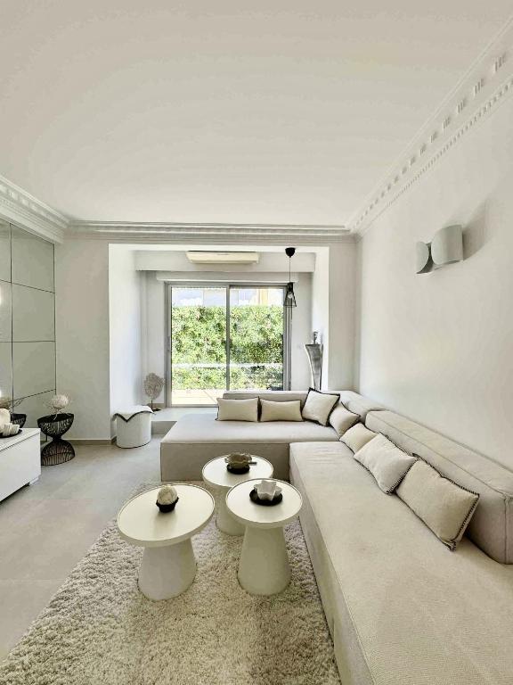 - un salon avec un grand canapé et 2 tables dans l'établissement Apt moderne et luxueux a Cannes Res Miramar, à Cannes