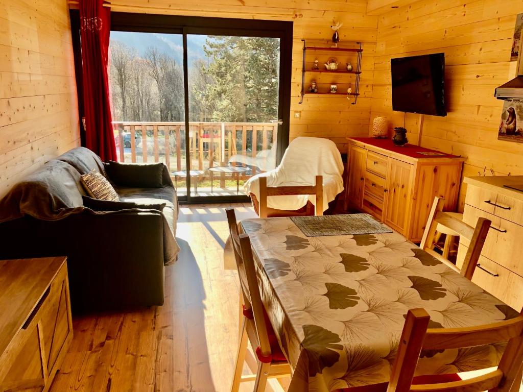 - un salon avec un canapé et une table dans une cabine dans l'établissement Le refuge, à Saint-Jean-Saint-Nicolas