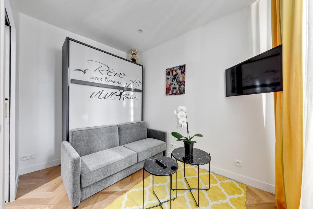 un salon avec un canapé et une télévision dans l'établissement Suite CD : Superb Parisian apartment, à Paris