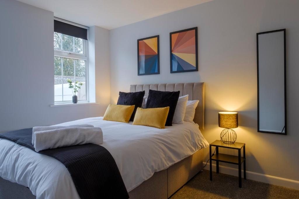 a bedroom with a large bed with two windows at Vibrant 2 Bed Apartment, FREE Parking, Bawtry Rd Doncaster - Hosted by Stay Host Save in Doncaster