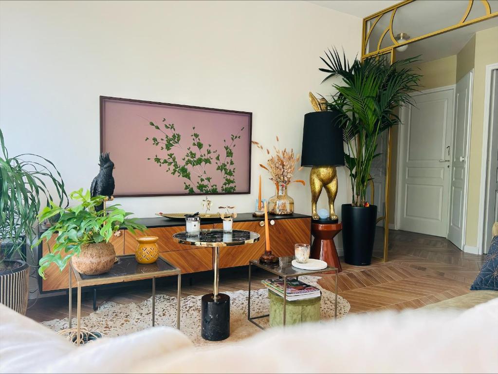 パリにあるLes Chambres de Davidの植物と大きな絵画が飾られたリビングルーム
