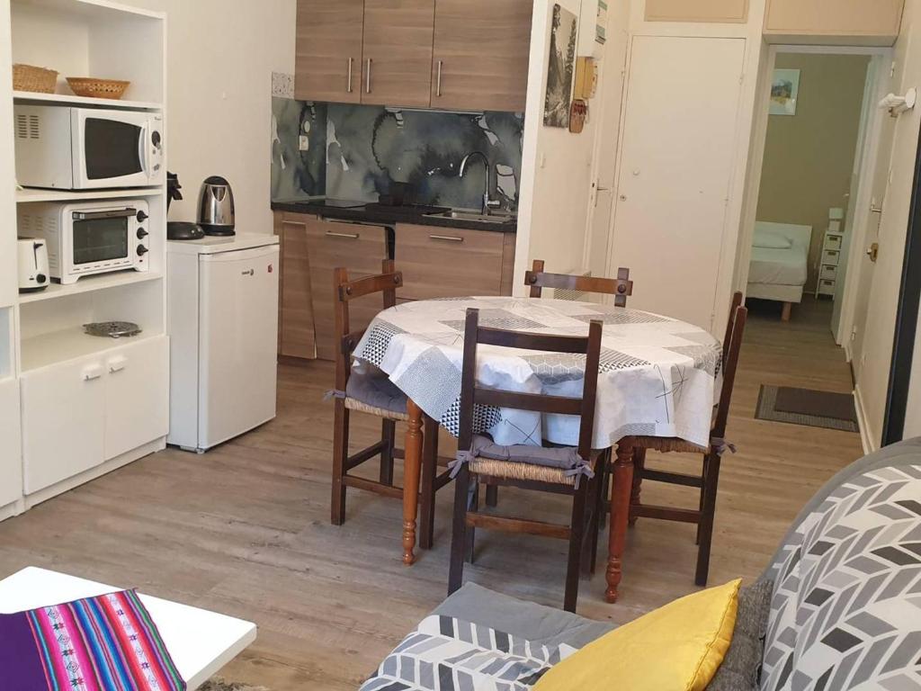 une cuisine avec une table et des chaises dans une pièce dans l'établissement Appartement 6 pers, cuisine équipée, près télécabine - FR-1-234-231, à Cauterets
