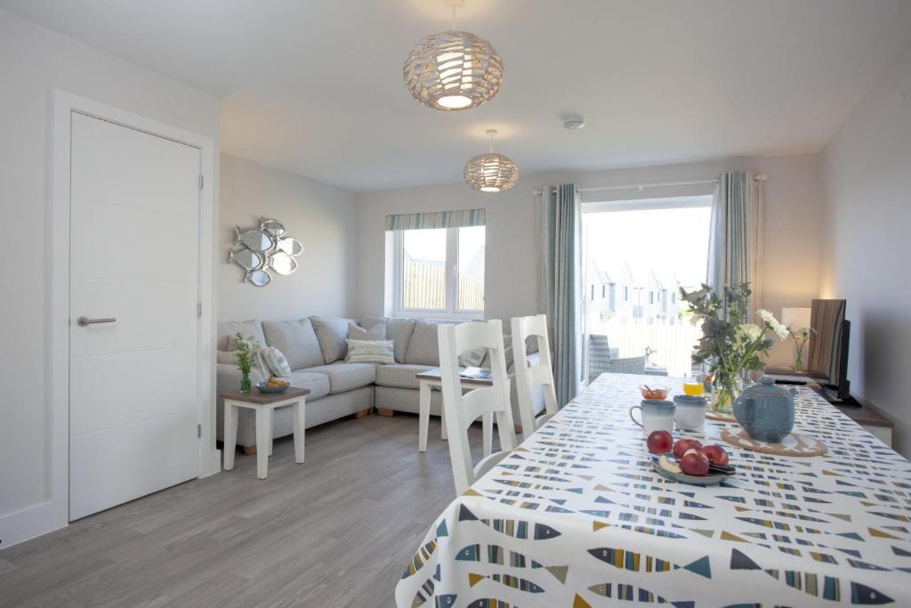 a living room with a table and a couch at Wish You Were Here - Hot Tub - Free Parking & Free WiFi in Newquay