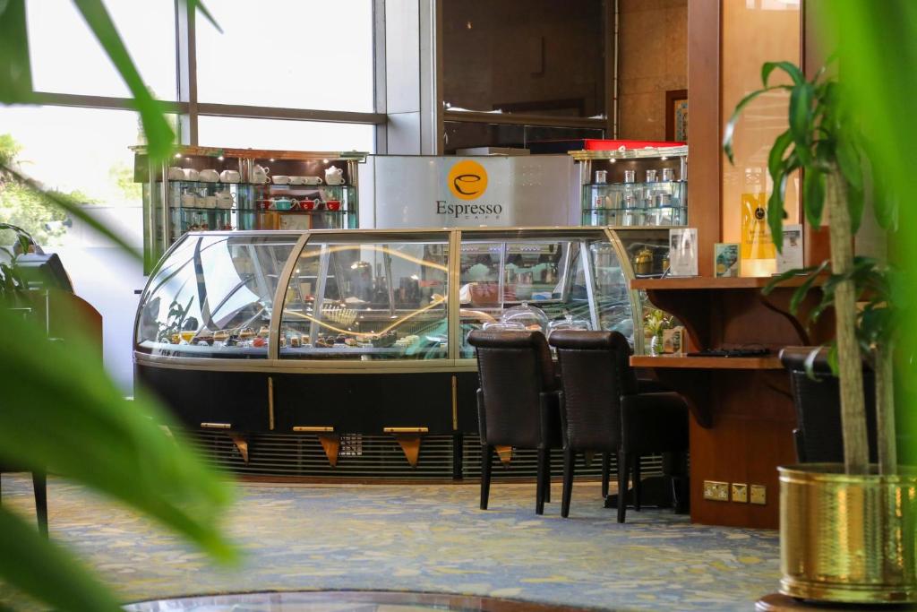 a restaurant with a bar with chairs in a room at Holiday Inn Kuwait Al Thuraya City by IHG in Kuwait