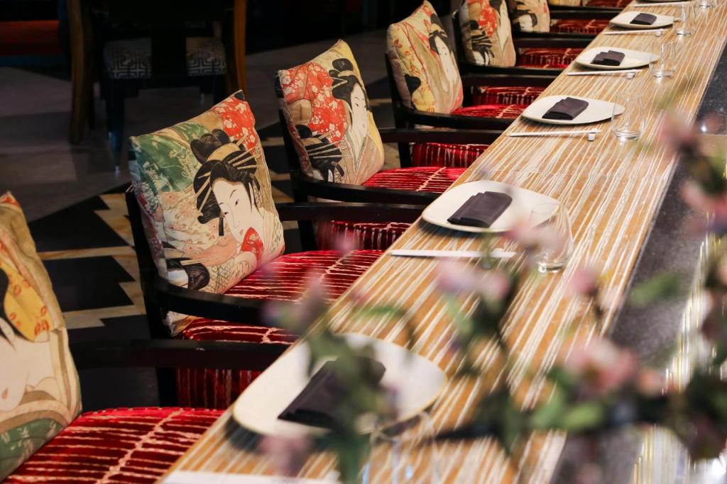 a row of long wooden tables with pillows at Holiday Inn Kuwait Al Thuraya City by IHG in Kuwait