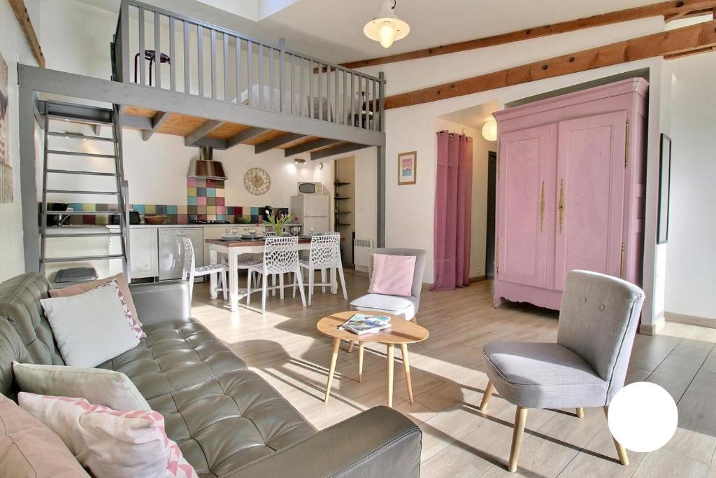 a living room with a couch and a pink door at Ty Glaz et ty Perenn, les gîtes de Rhuys in Sarzeau