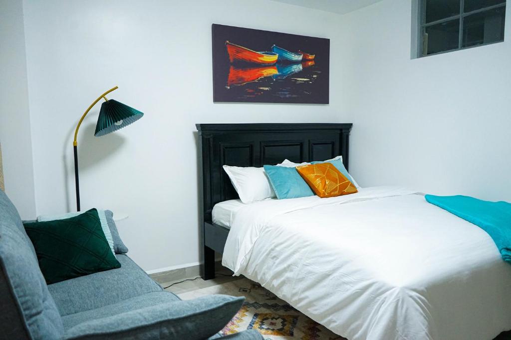 a bedroom with a bed and a chair and a lamp at The Nestie Studio in Nairobi
