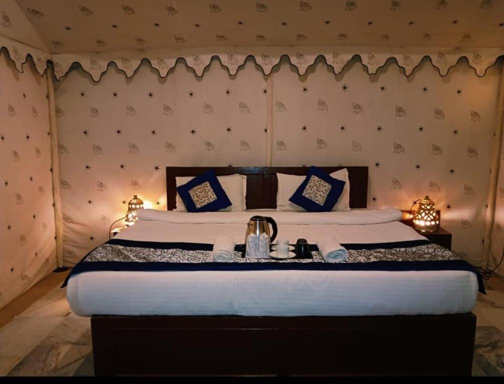 Un dormitorio con una cama grande con almohadas azules y blancas. en Barna desert camp jaisalmer, en Kūri