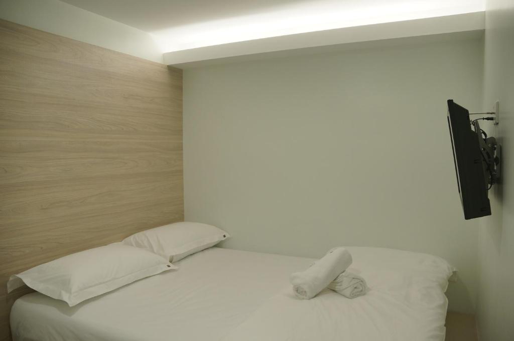 a bedroom with a bed with white sheets and pillows at Hotel 57 USJ 21 Subang Jaya in Subang Jaya