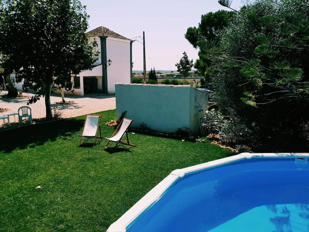 Un patio con dos sillas y una piscina. en Quinta de Loubite, en Lagoa