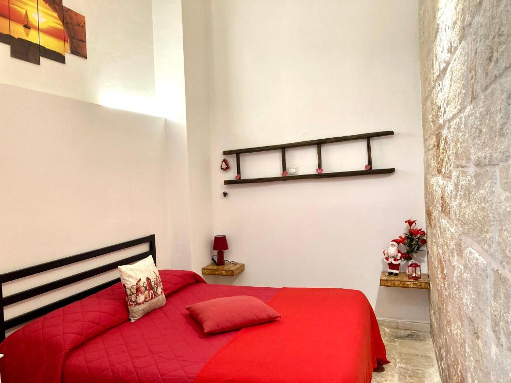 a bedroom with a red bed with a red blanket at Antica Pietra in Polignano a Mare