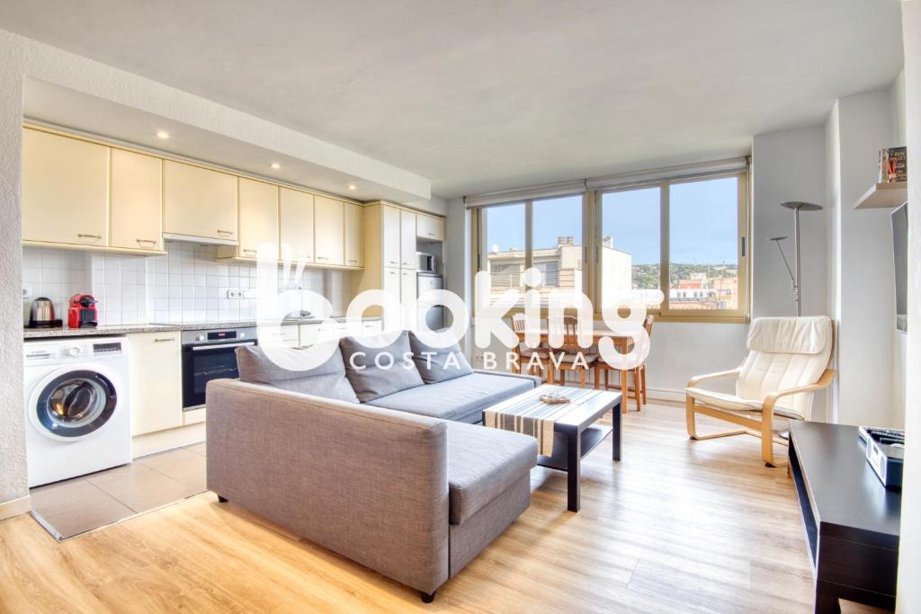 eine Küche und ein Wohnzimmer mit einer Couch und einem Tisch in der Unterkunft La Rambla in Sant Feliu de Guixols