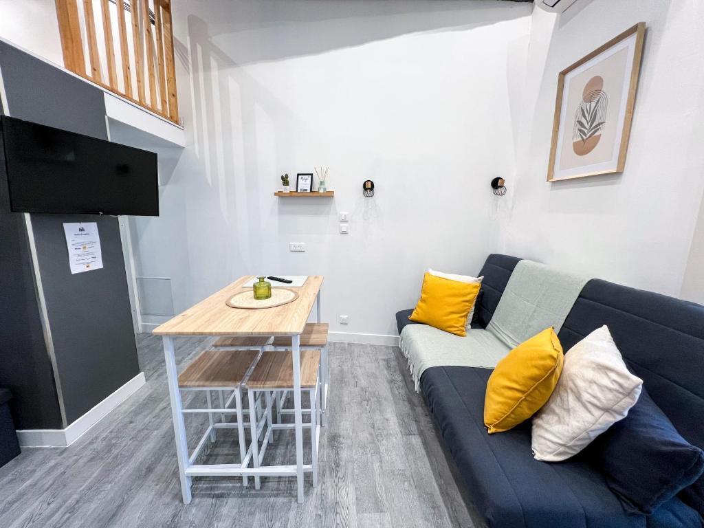 un salon avec un canapé bleu et une table dans l'établissement L'Escapade - Charmant studio au cœur du village, à Saint-Maximin-la-Sainte-Baume