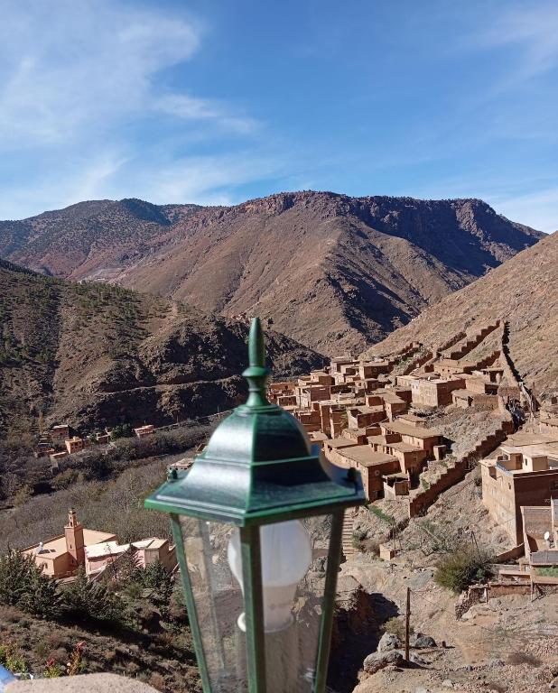 a green street light with a village in the mountains at Atlas Pearl lodge in Imlil