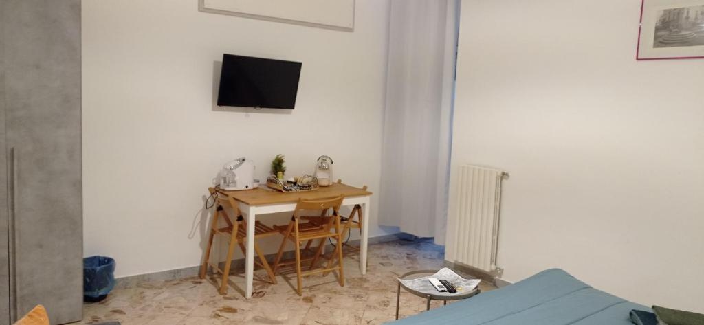 a room with a table and a television on a wall at CasaRA in Bari
