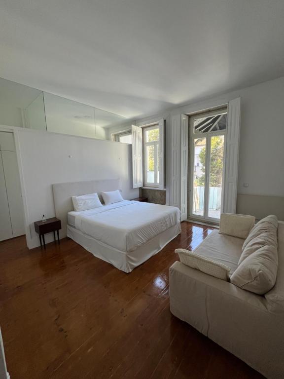 een slaapkamer met 2 bedden en een bank bij Duke`s Retreat in Porto