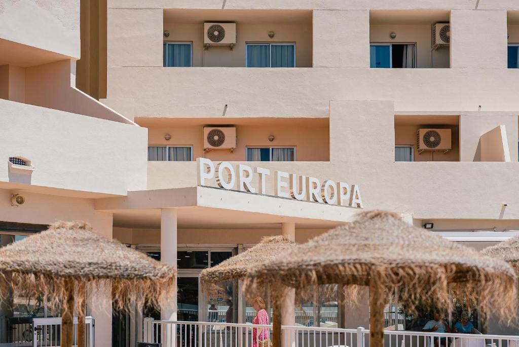 a hotel with straw umbrellas in front of it at Port Europa in Calpe
