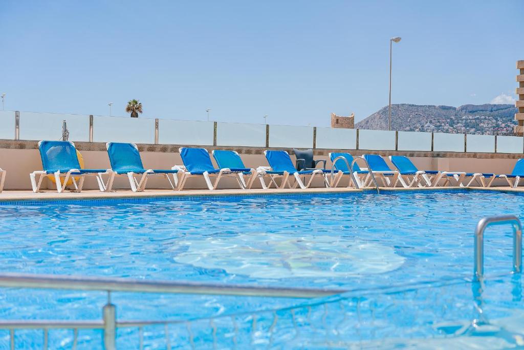 a row of blue chairs in a swimming pool at Port Europa in Calpe