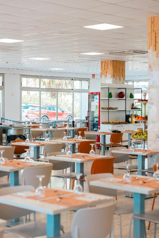 an empty restaurant with tables and chairs and windows at Port Europa in Calpe