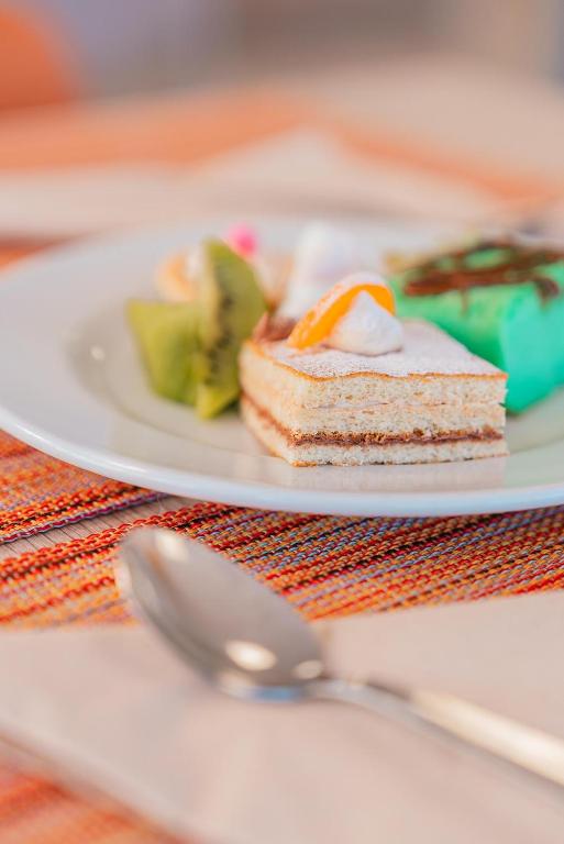 a plate with a piece of cake and a spoon at Port Europa in Calpe