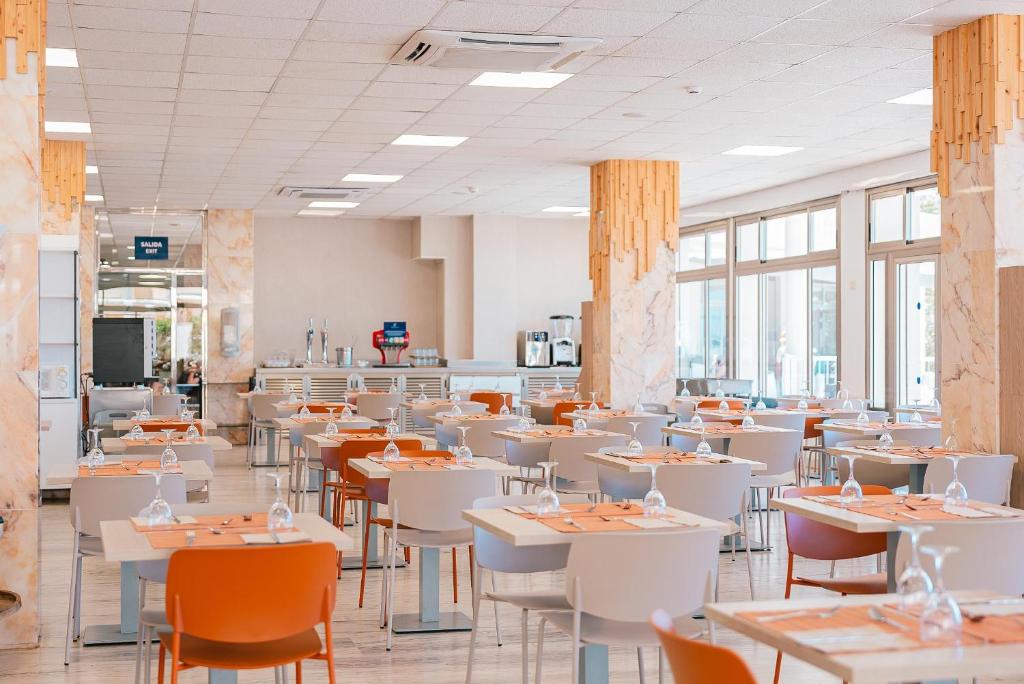 a dining room with white tables and chairs at Port Europa in Calpe