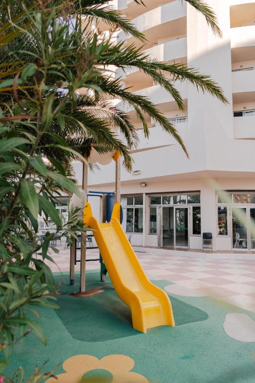 a yellow slide in a building with trees at Port Europa in Calpe