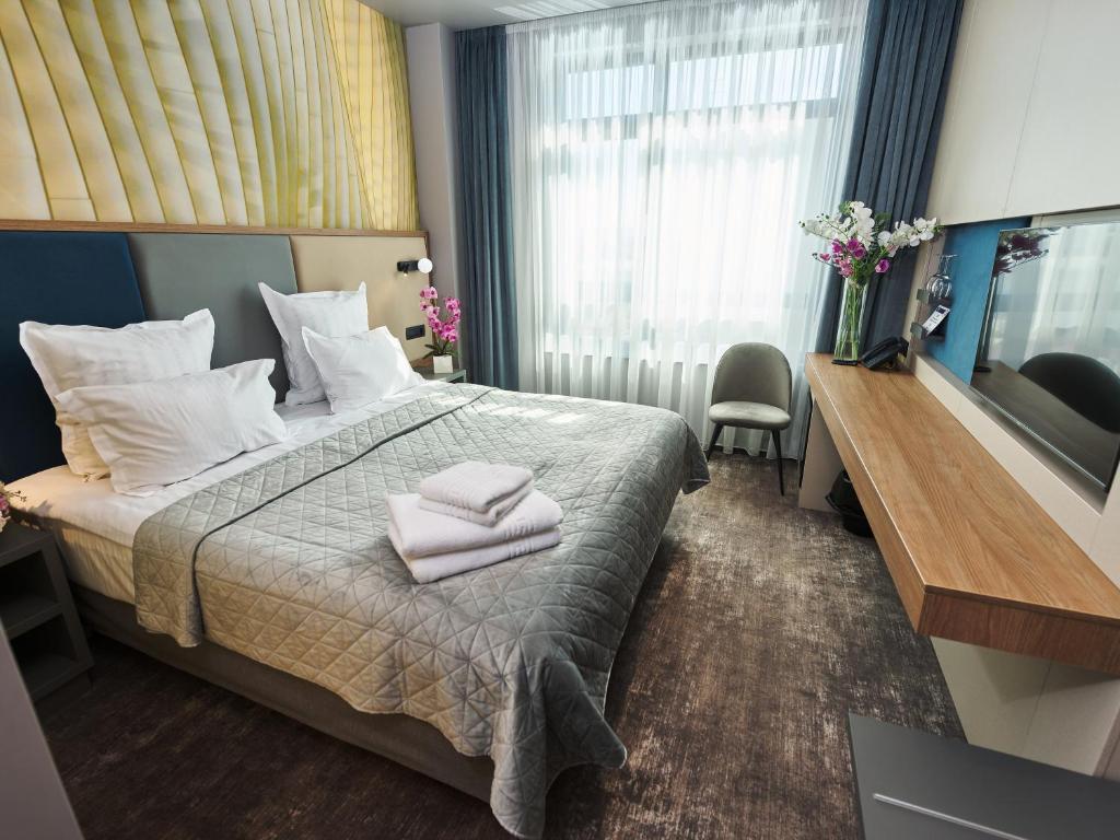 a hotel room with a bed with towels on it at Hotel EMD in Bacău