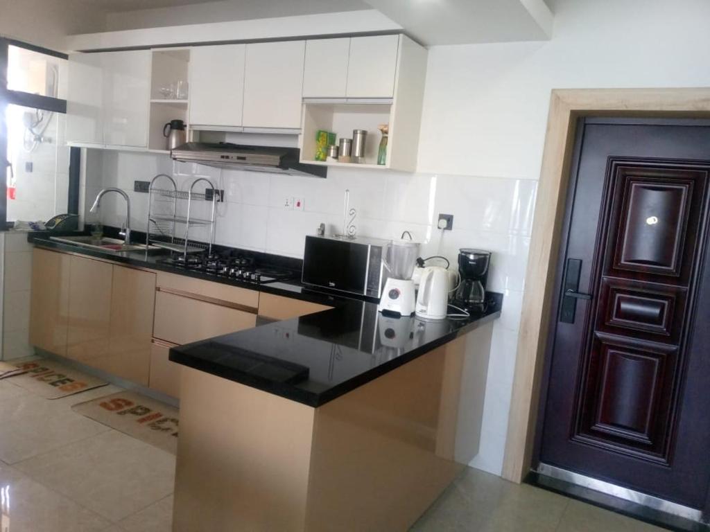 a kitchen with a black counter top in a room at The Heart of Urban in Nairobi