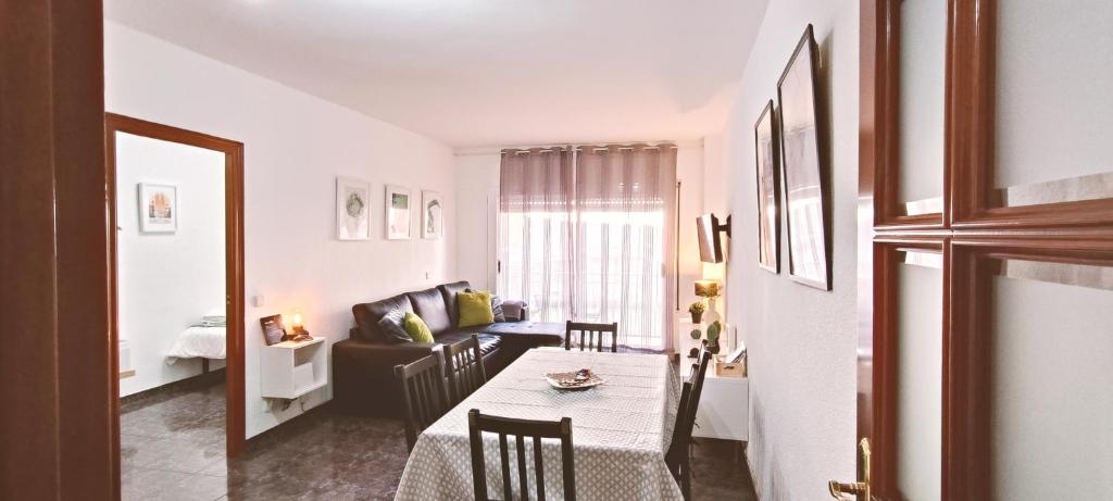 un soggiorno con un tavolo e un divano di Apartamento Centric para 6 cerca de a playa y el tren a Premiá de Mar